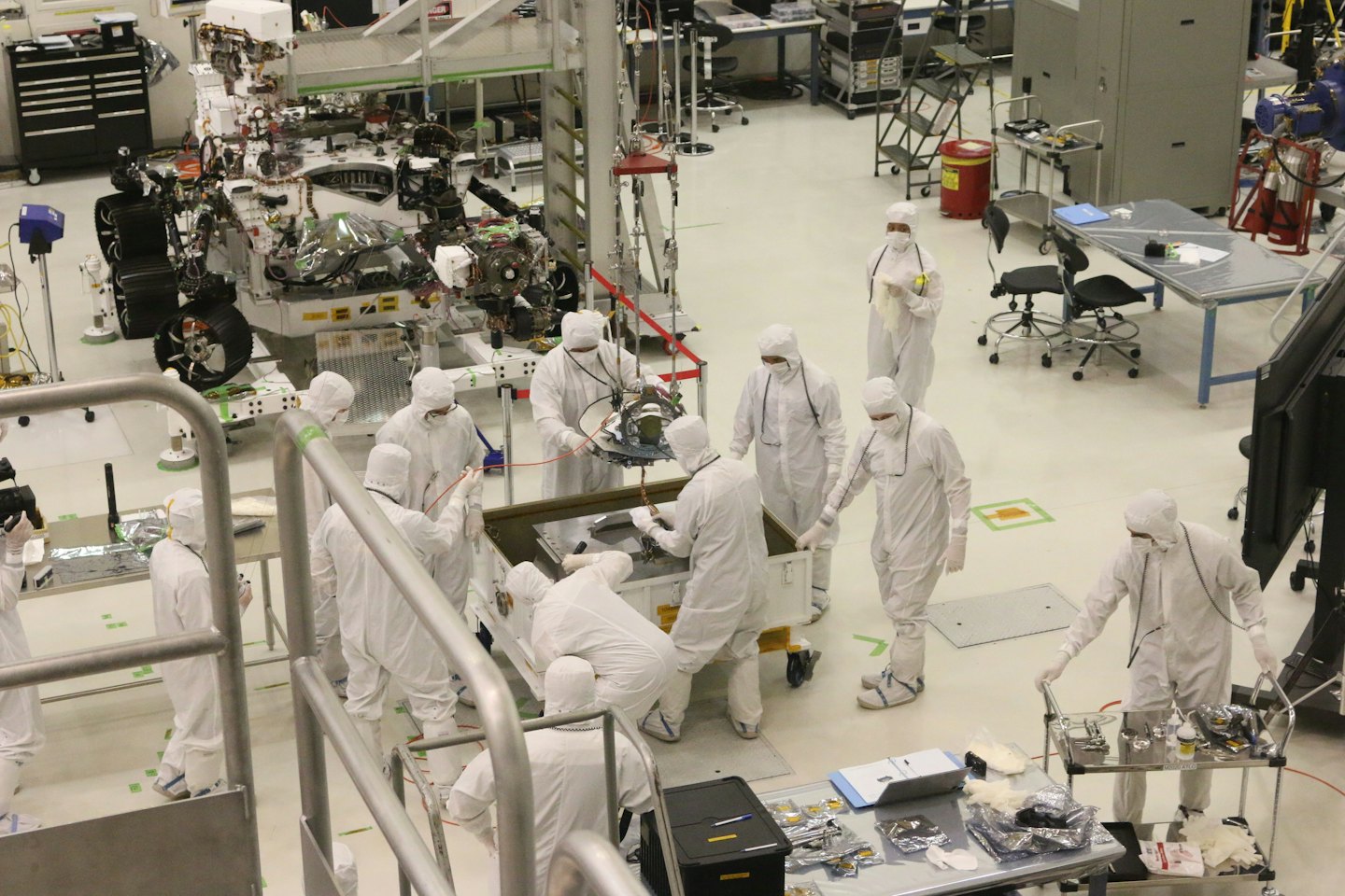 Engineers assemble a complex robotic vehicle in a cleanroom laboratory.